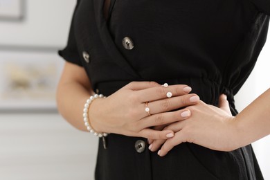 Photo of Woman wearing elegant pearl jewelry indoors, closeup