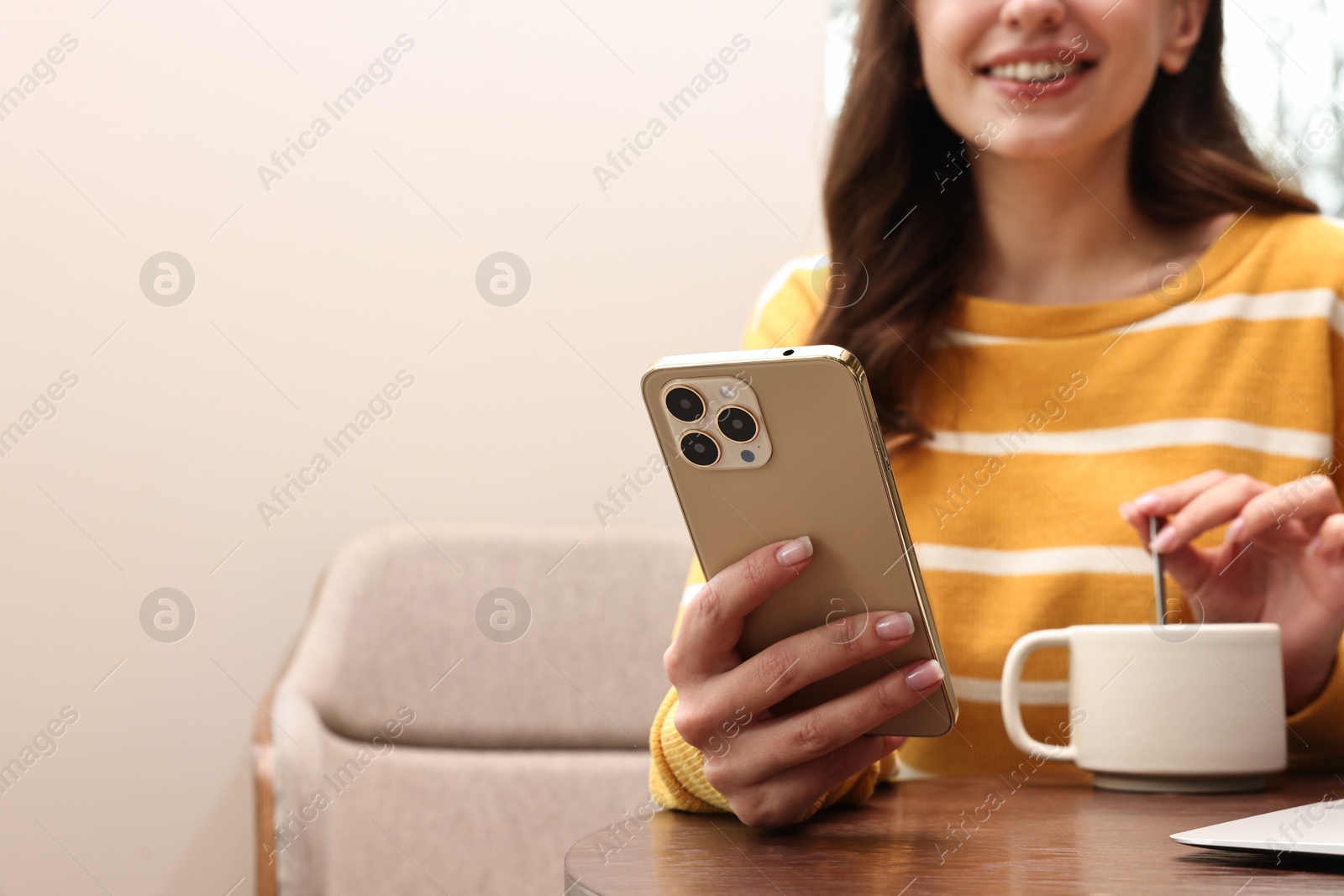 Photo of Smiling woman with smartphone having coffee break in cafe, closeup. Space for text