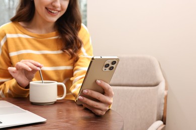 Photo of Smiling woman with smartphone having coffee break in cafe, closeup. Space for text