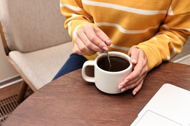 Photo of Woman having coffee break at wooden table in cafe, closeup