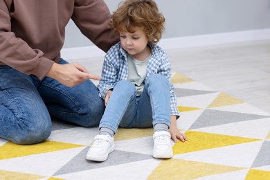 Photo of Resentful little boy and his father arguing at home, space for text