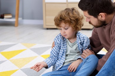 Photo of Resentful little boy and his father at home, space for text. Family dispute