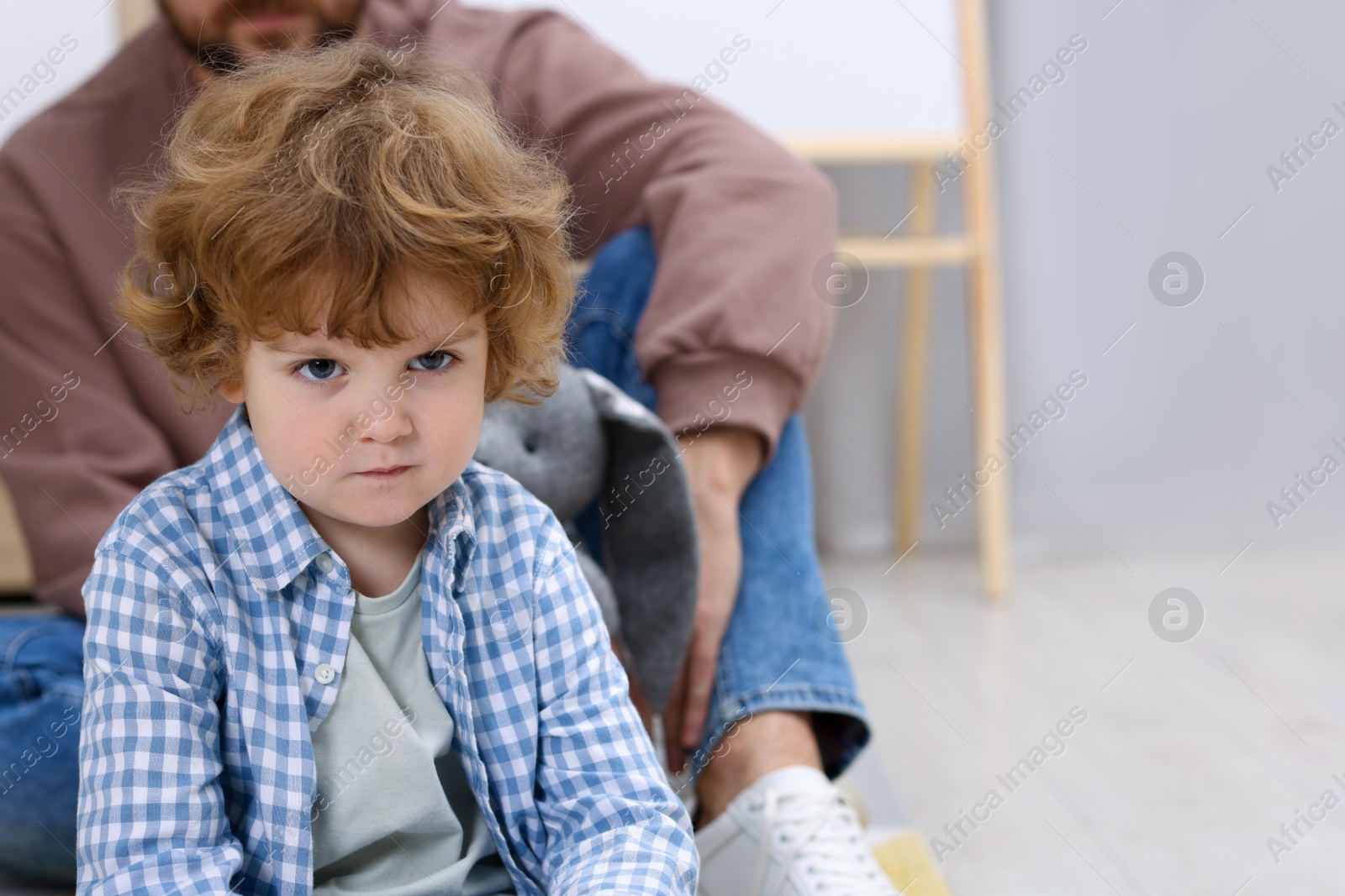 Photo of Resentful little boy and his father at home, space for text. Family dispute