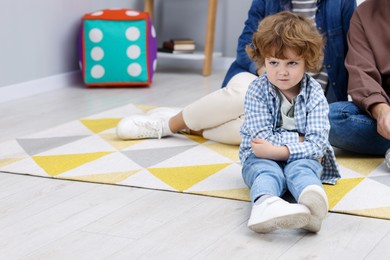 Photo of Resentful little boy and his parents at home, space for text. Family dispute