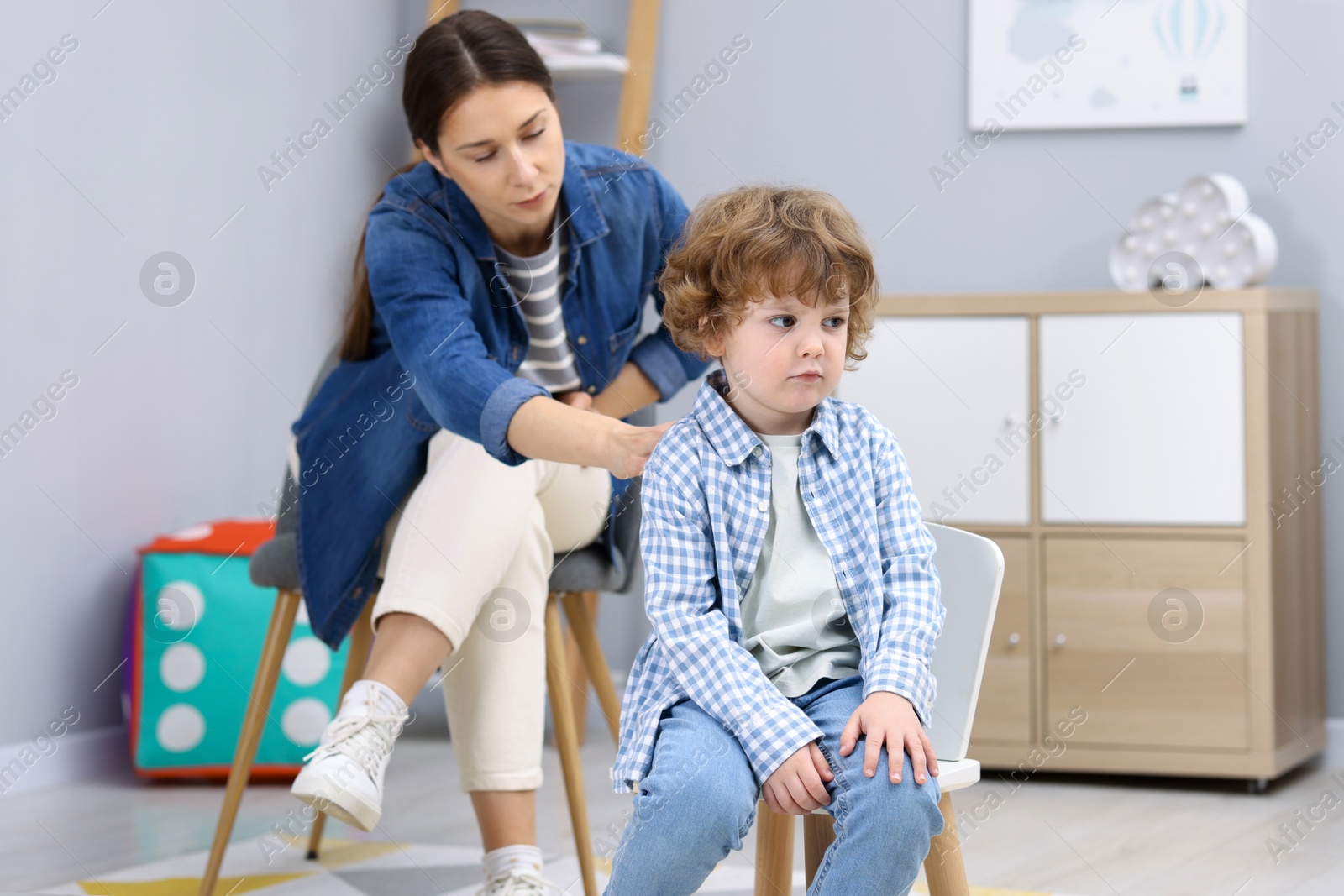 Photo of Resentful little boy and his mother arguing at home