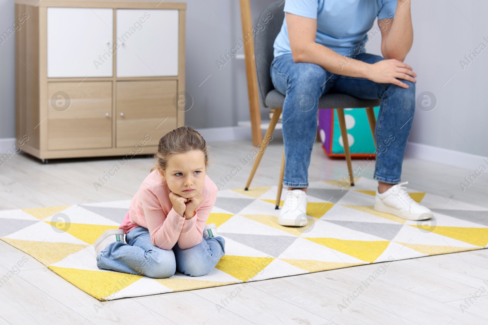 Photo of Resentful little girl and her father at home. Family dispute