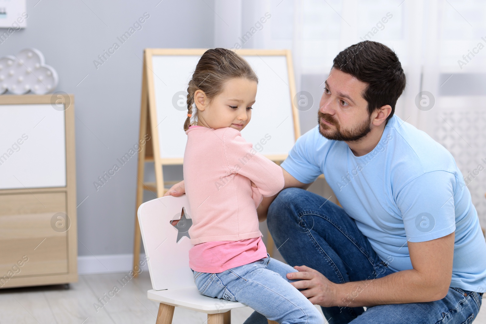 Photo of Resentful little girl and her father arguing at home