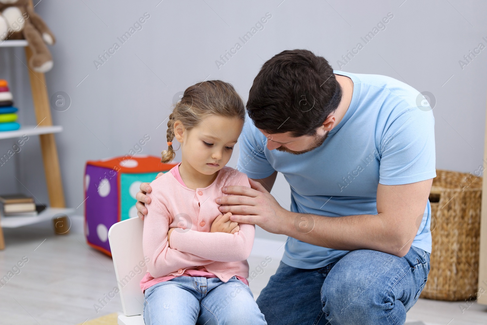 Photo of Resentful little girl and her father at home. Family dispute