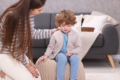 Photo of Resentful little boy and his mother arguing at home