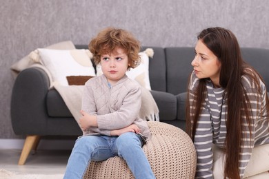 Photo of Resentful little boy and his mother arguing at home