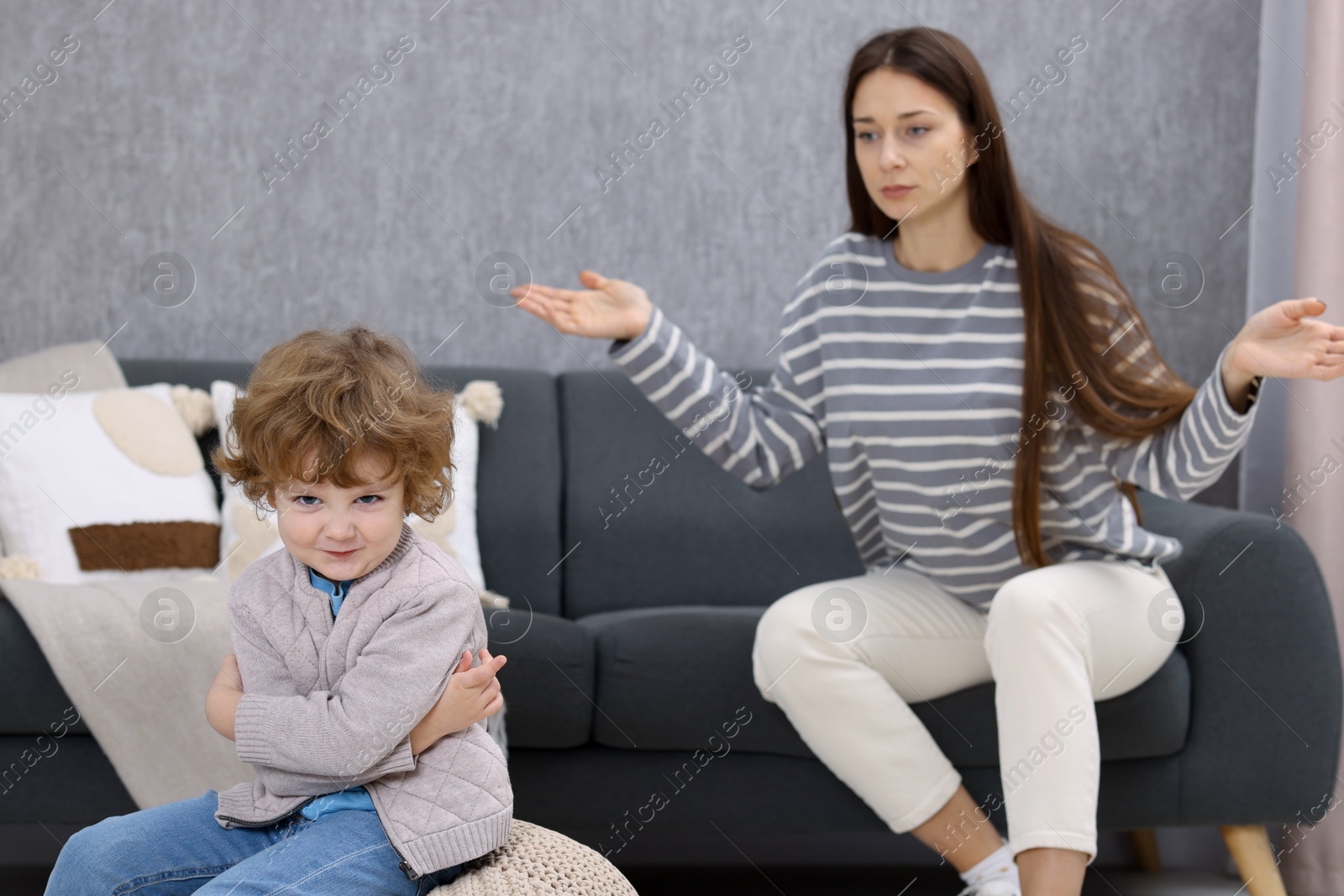 Photo of Resentful little boy and his mother arguing at home