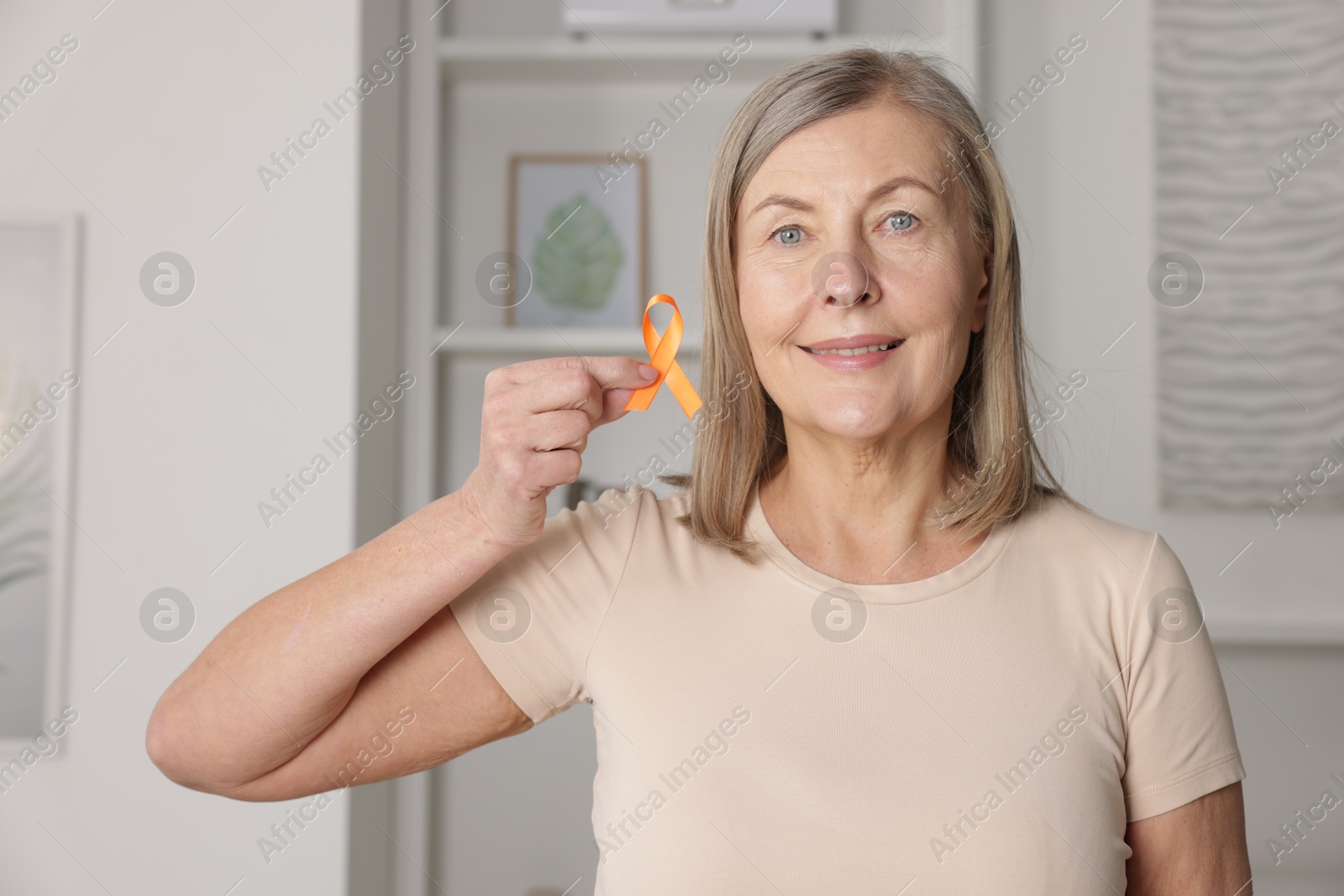 Photo of Multiple Sclerosis awareness. Woman with orange ribbon at home