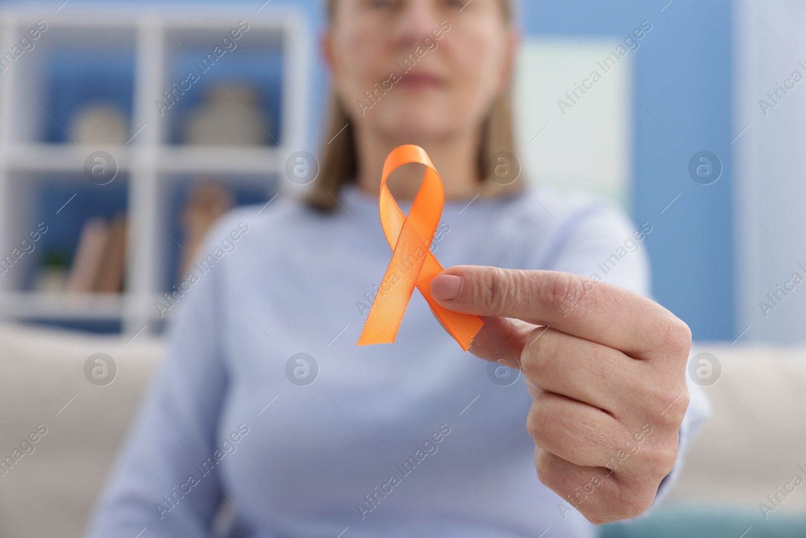 Photo of Multiple Sclerosis awareness. Woman with orange ribbon at home, closeup