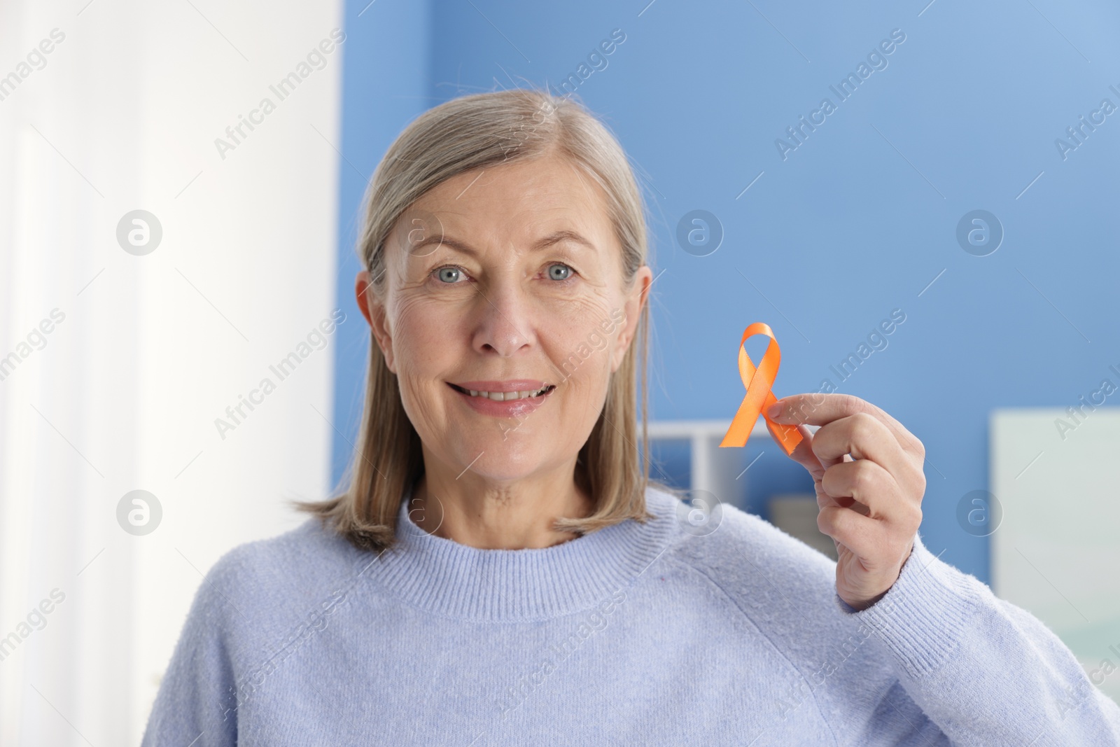 Photo of Multiple Sclerosis awareness. Woman with orange ribbon at home