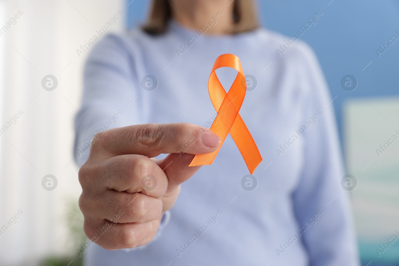 Photo of Multiple Sclerosis awareness. Woman with orange ribbon at home, closeup