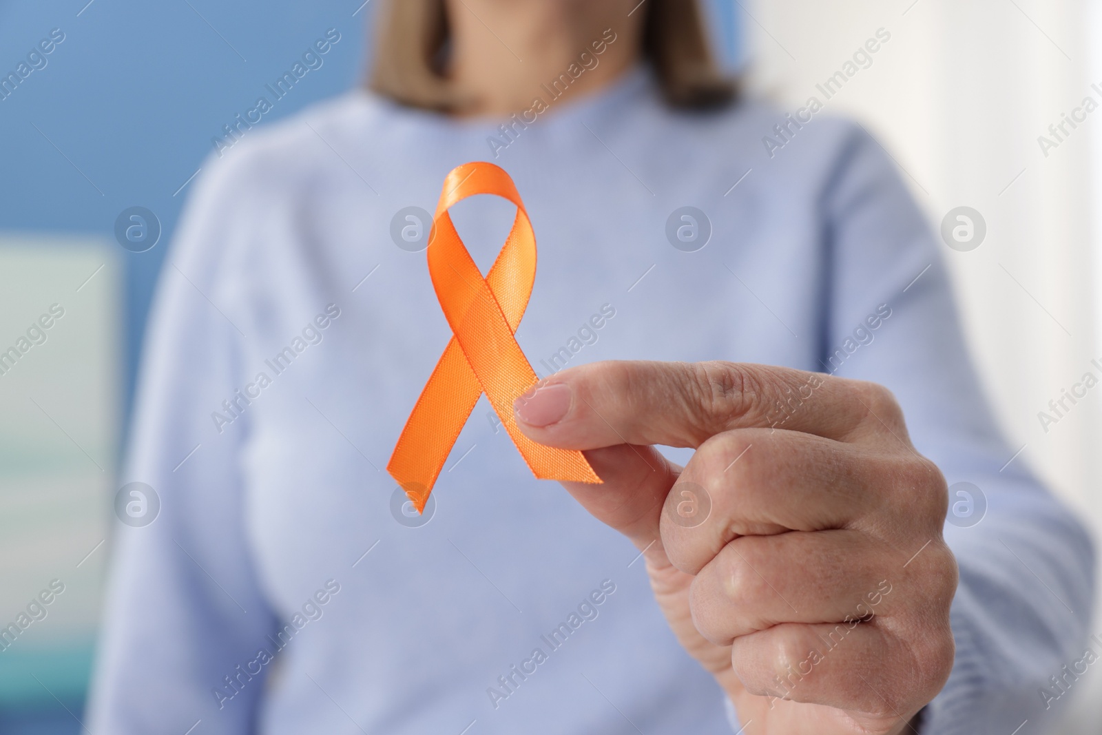 Photo of Multiple Sclerosis awareness. Woman with orange ribbon at home, closeup