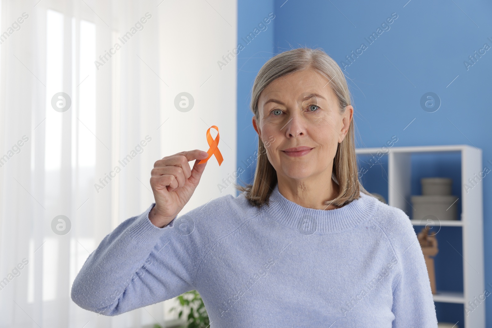 Photo of Multiple Sclerosis awareness. Woman with orange ribbon at home