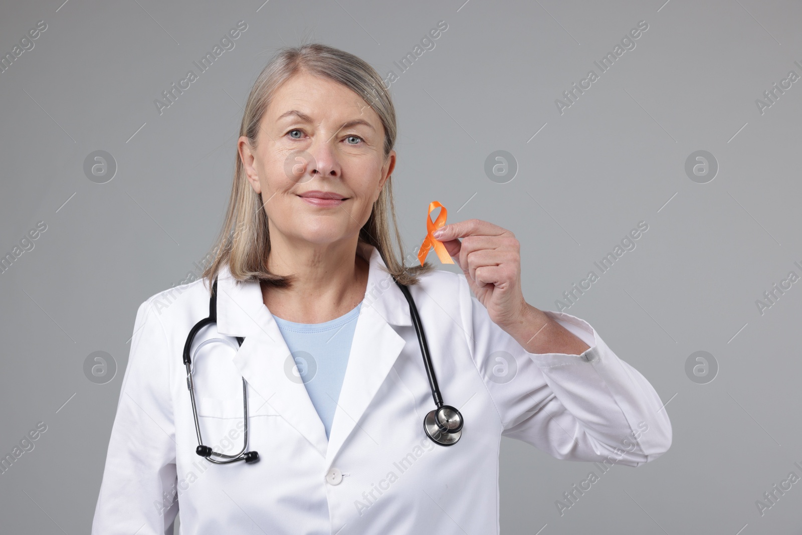 Photo of Multiple Sclerosis awareness. Doctor with orange ribbon on light grey background