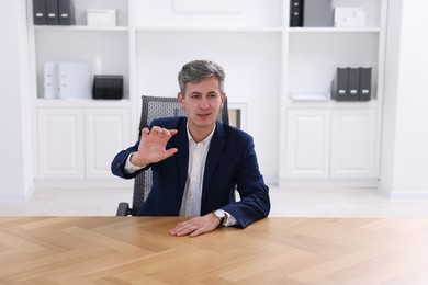 Photo of Man showing something at desk in office