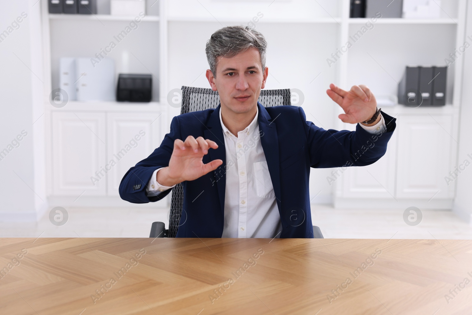 Photo of Man showing something at desk in office