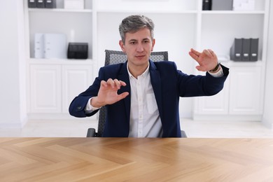 Photo of Man showing something at desk in office