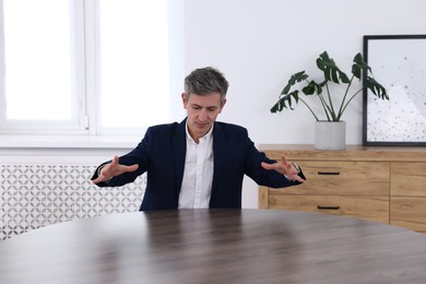 Photo of Man showing something at desk in office