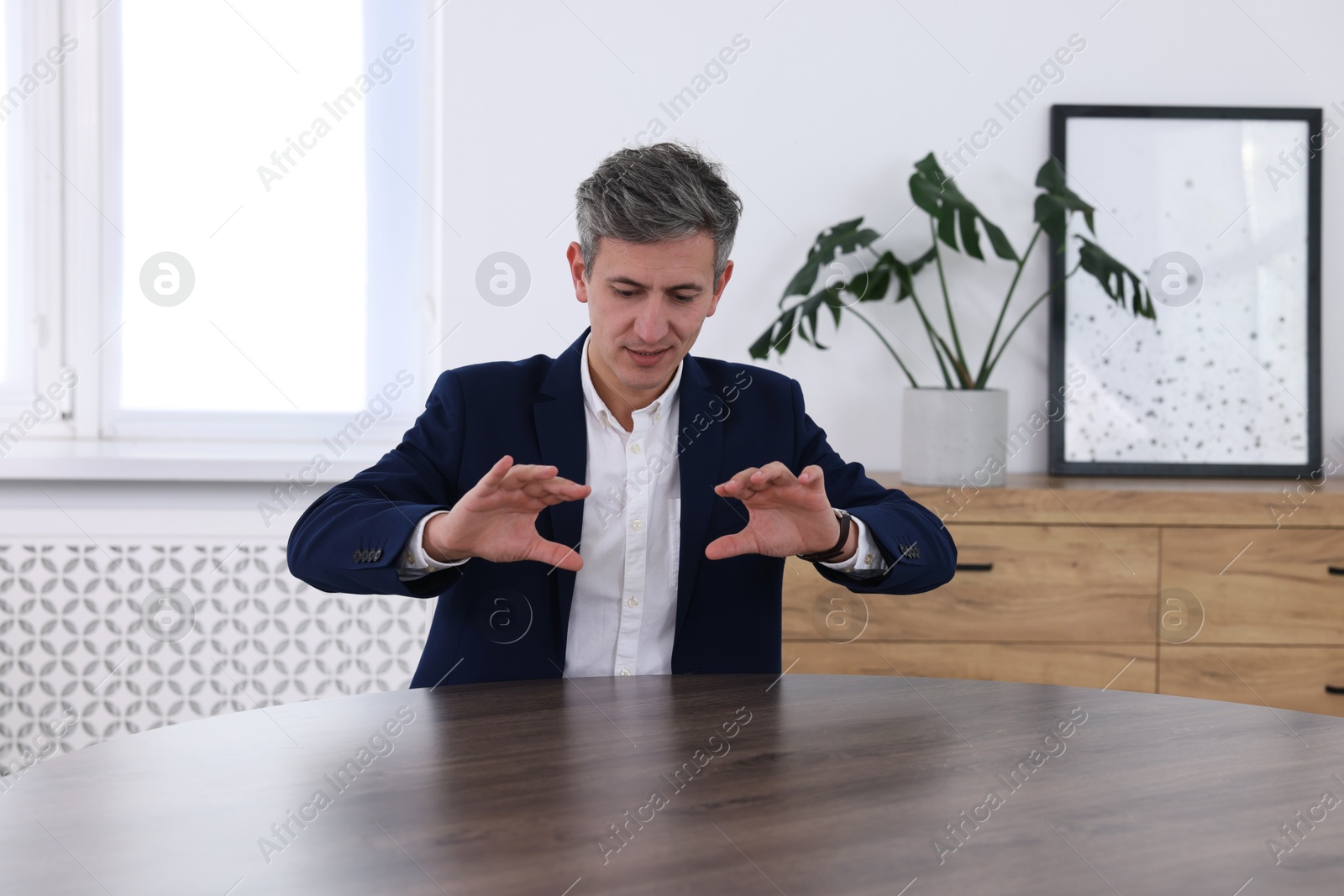 Photo of Man showing something at desk in office