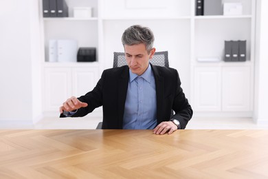 Photo of Man showing something at desk in office