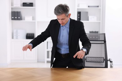 Photo of Man showing something at desk in office