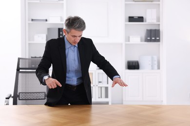 Photo of Man showing something at desk in office