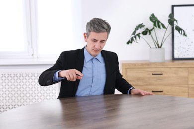 Photo of Man pointing at something on desk in office