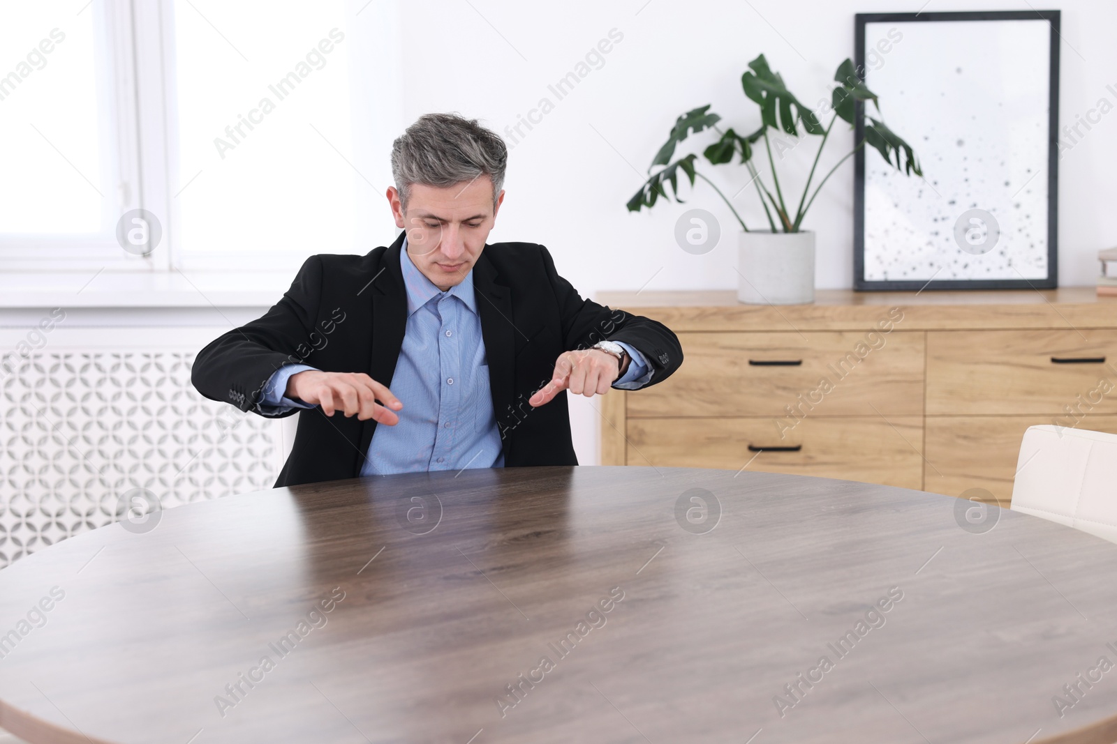 Photo of Man pointing at something on desk in office