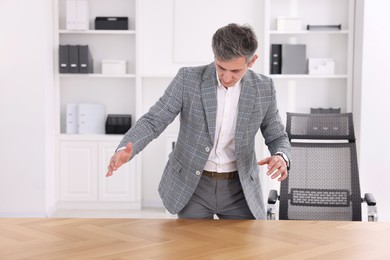 Photo of Man showing something at desk in office