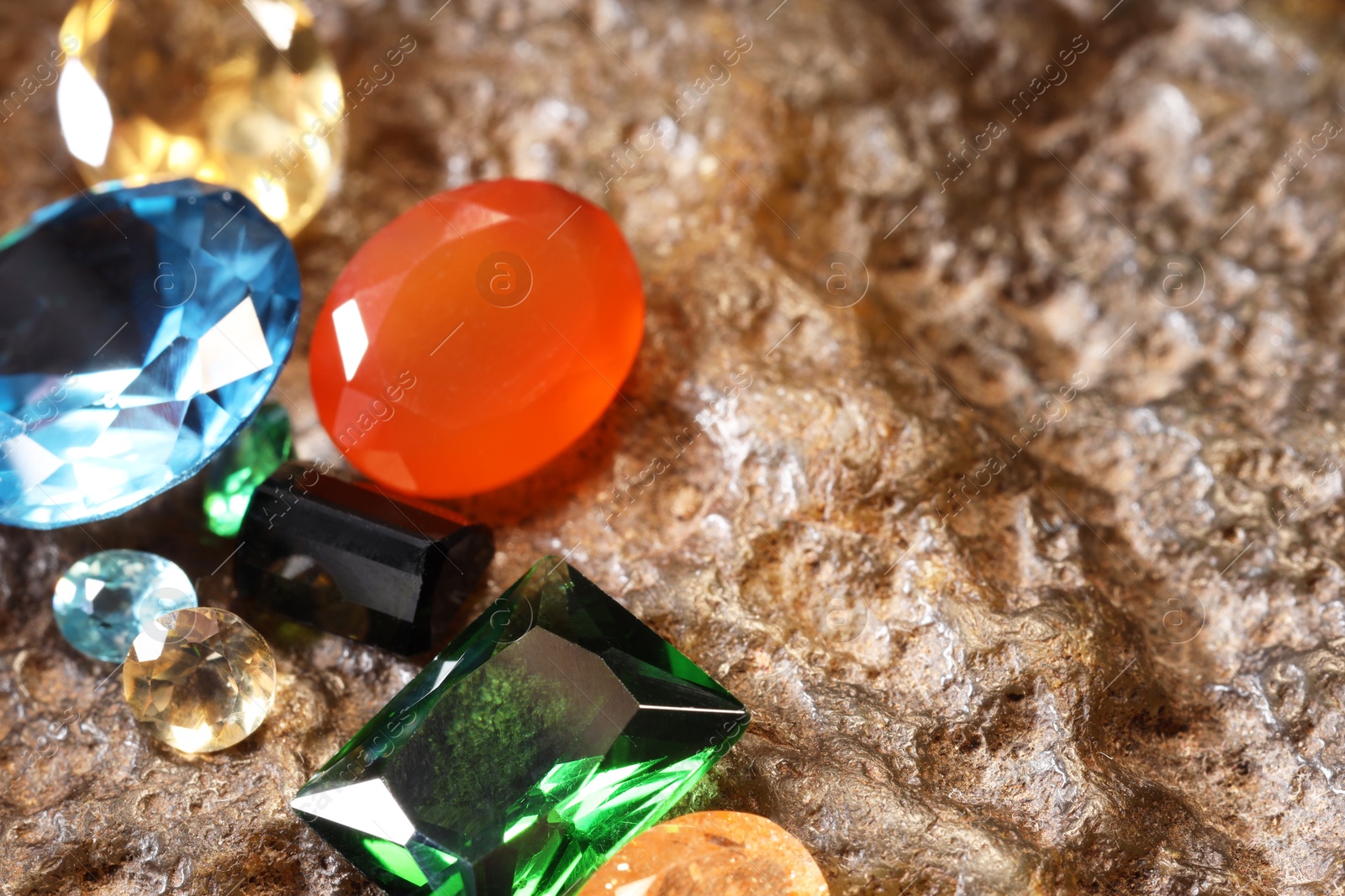 Photo of Beautiful shiny colorful gemstones on rock, closeup