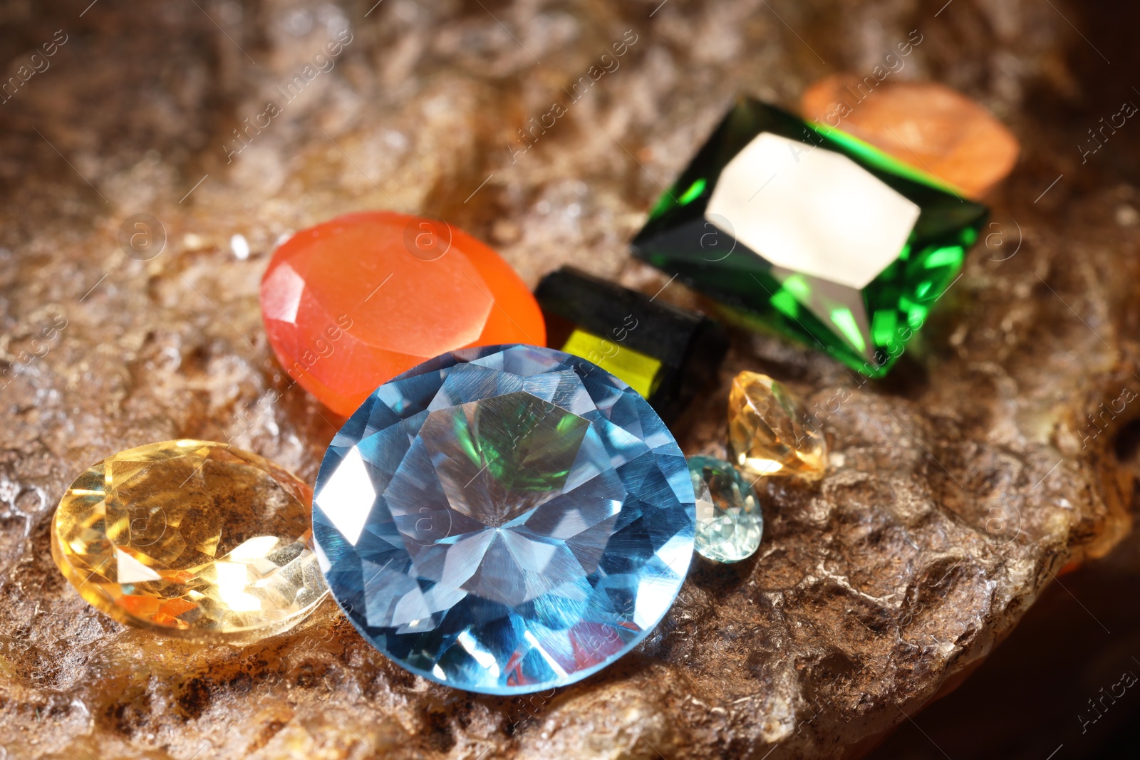 Photo of Beautiful shiny colorful gemstones on rock, closeup