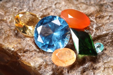 Photo of Beautiful shiny colorful gemstones on rock, closeup