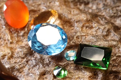 Photo of Beautiful shiny colorful gemstones on rock, closeup