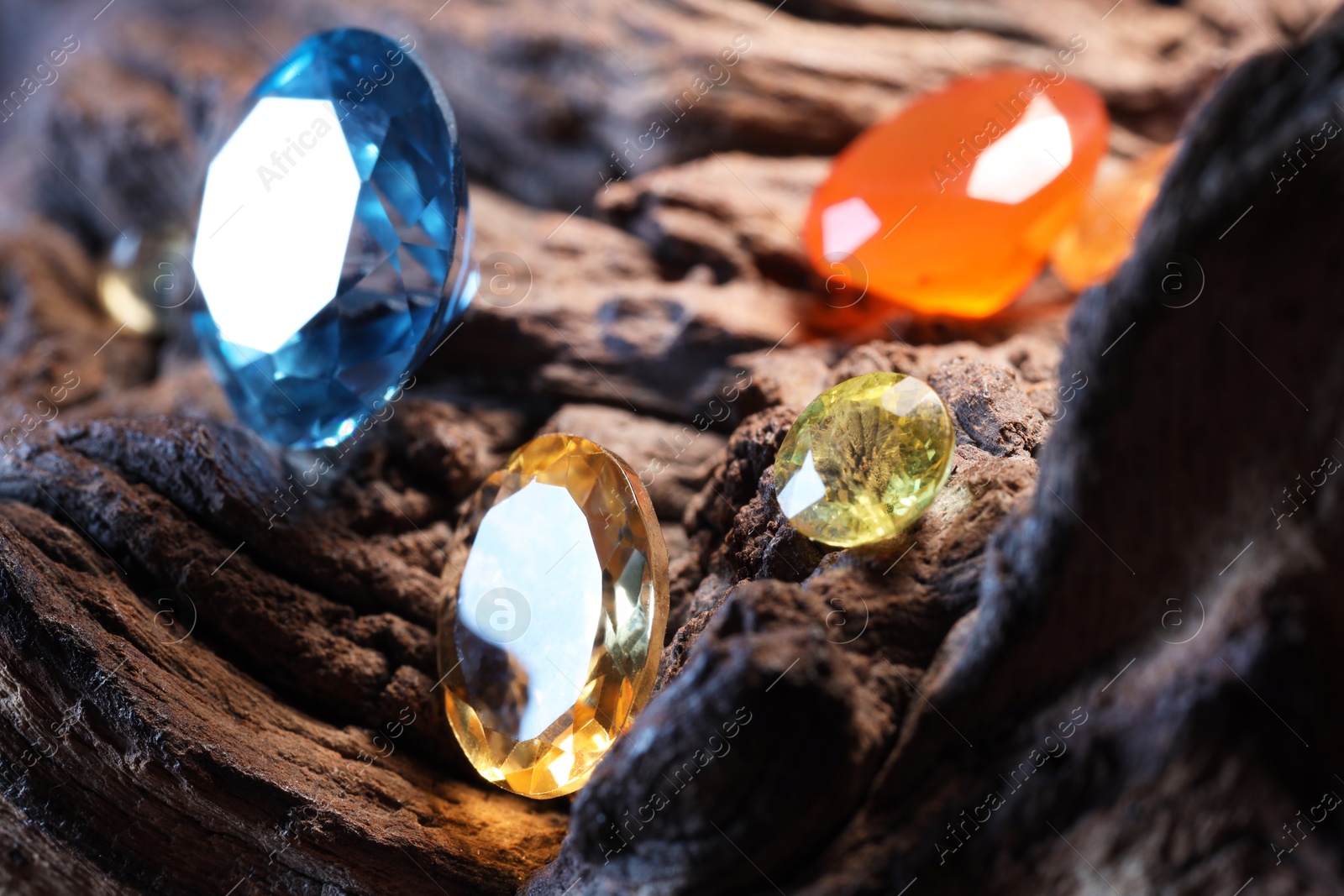 Photo of Beautiful shiny colorful gemstones on stone, closeup