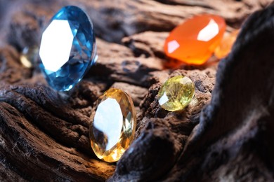 Photo of Beautiful shiny colorful gemstones on stone, closeup