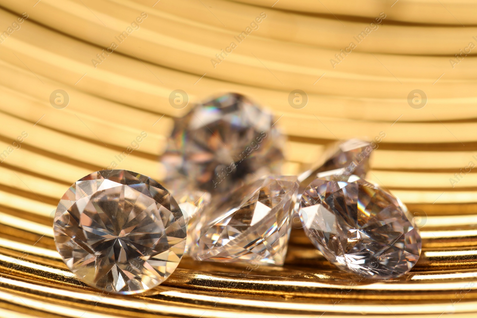 Photo of Beautiful shiny gemstones on golden tray, closeup