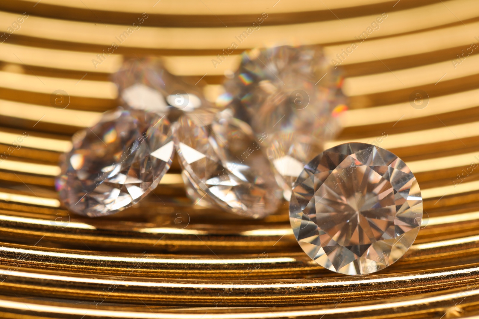 Photo of Beautiful shiny gemstones on golden tray, closeup