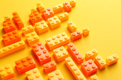 Photo of Constructor toy. Many building blocks on yellow background, above view