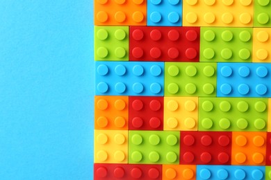 Photo of Constructor toy. Many colorful building blocks on light blue background, top view