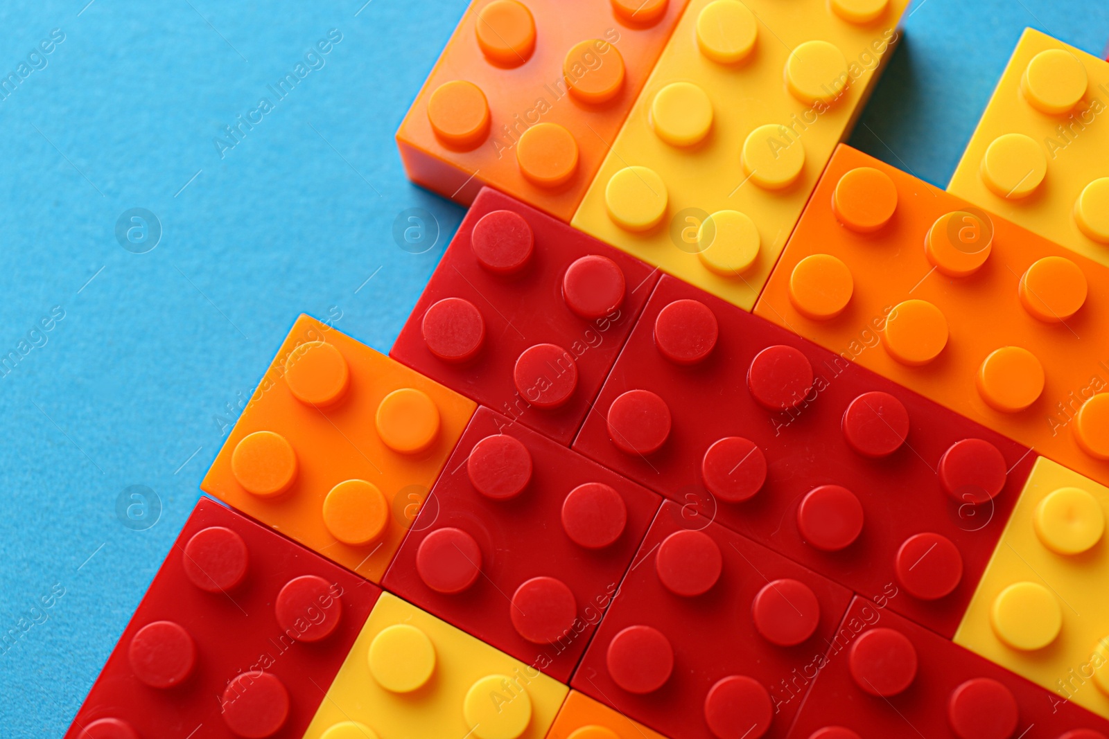 Photo of Constructor toy. Many colorful building blocks on light blue background, top view