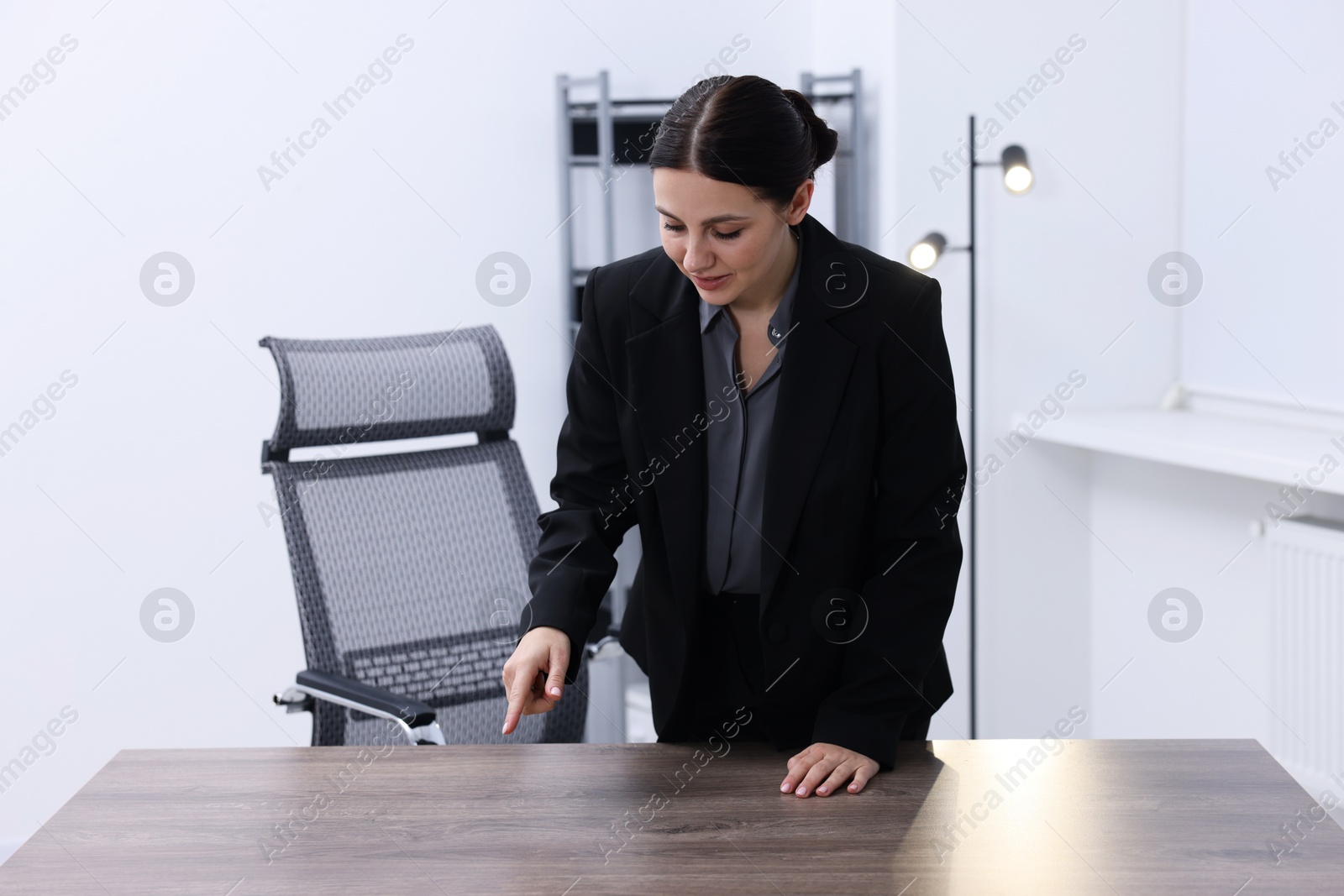 Photo of Beautiful woman pointing at something in office