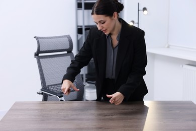 Photo of Beautiful woman showing something at wooden table in office