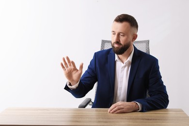 Man showing something at wooden desk in office, space for text