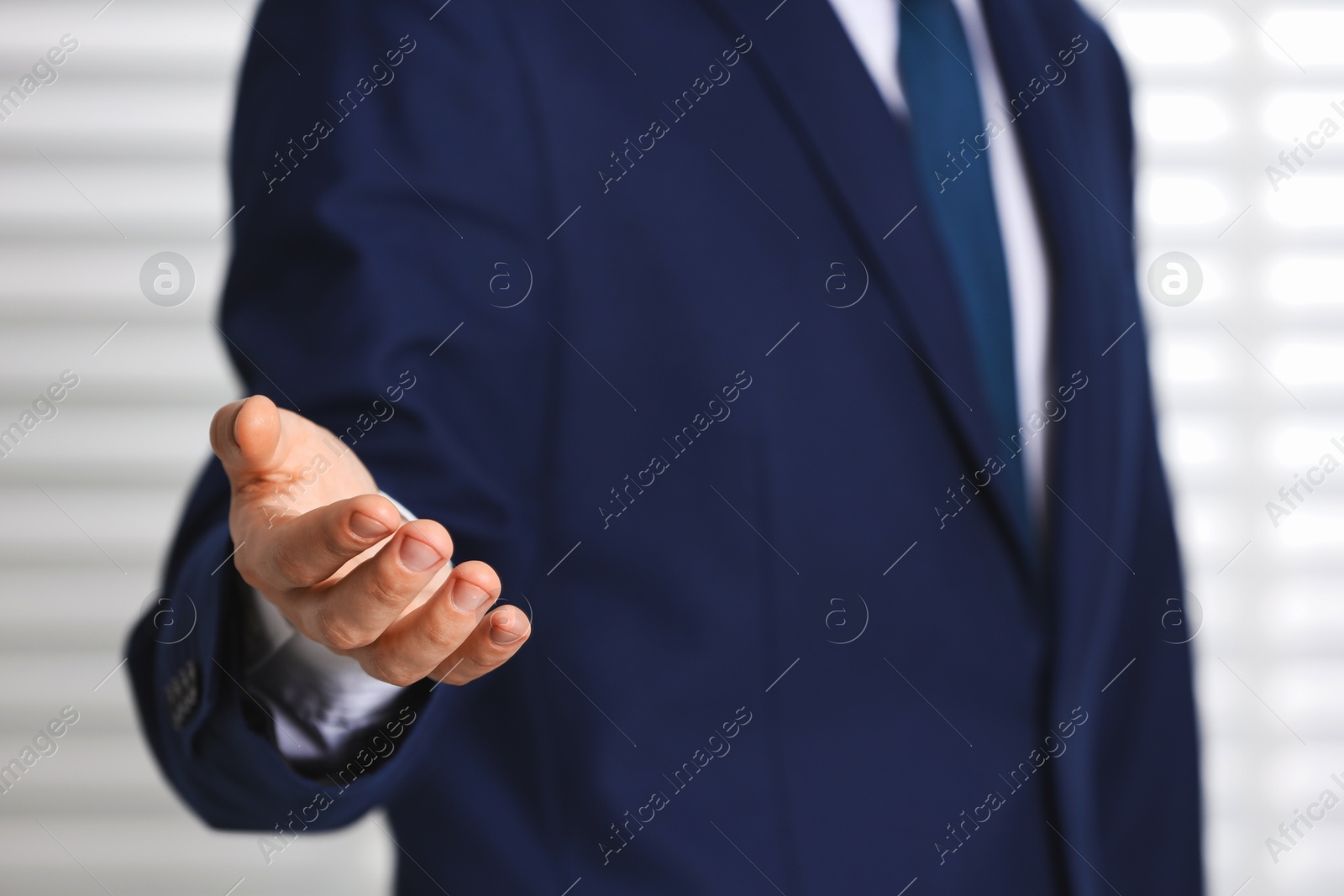 Photo of Man offering helping hand on light background, closeup