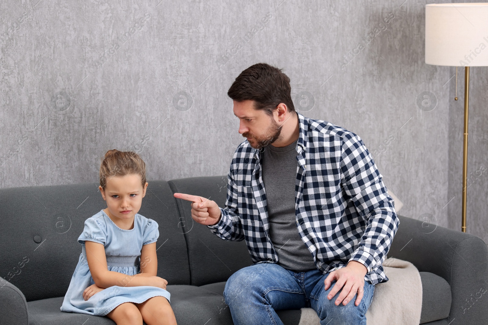 Photo of Resentful little girl and her father arguing at home