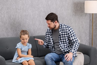 Photo of Resentful little girl and her father arguing at home